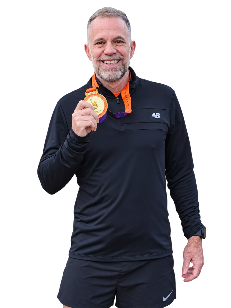 César Aarão sorrindo com sua medalha, em retrato recortado a partir da foto original